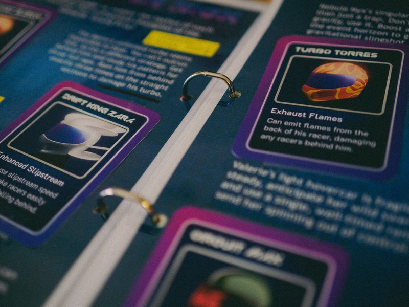 The binder with brass fasteners and racing game cards